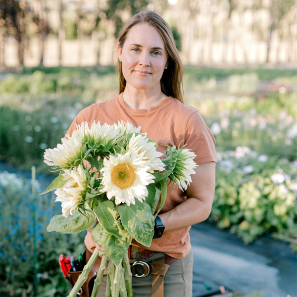 Jennifer Barnard holding sunflowers in a field